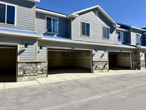 View of side of home with stone siding and an attached garage