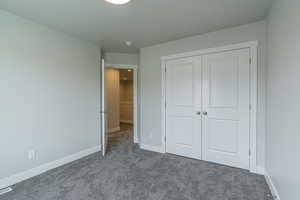 Unfurnished bedroom featuring carpet flooring and a closet