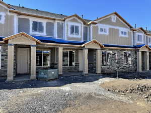 View of front facade with stone siding and a porch