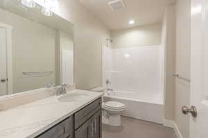 Bathroom featuring shower / tub combination, vanity, and light tile patterned flooring
