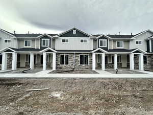 View of front of property featuring stone siding and covered porch