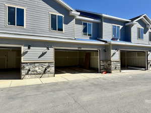 View of side of home featuring stone siding and an attached garage
