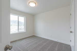 Unfurnished room featuring carpet flooring and a mountain view
