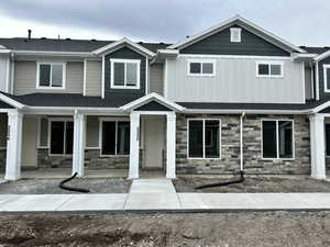 Craftsman-style home featuring stone siding, board and batten siding, and covered porch