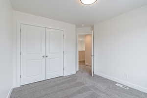 Unfurnished bedroom featuring carpet floors and a closet