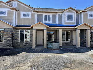 View of front of home with stone siding and covered porch