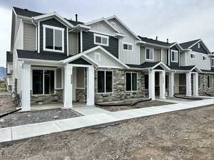 Craftsman-style home featuring board and batten siding, stone siding, and a porch