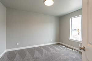 Empty room with carpet and baseboards