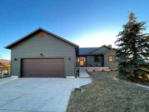 Ranch-style house with concrete driveway, a front yard, and a garage