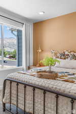 Bedroom featuring carpet, a mountain view, and a textured ceiling