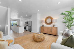 Living area featuring recessed lighting, light wood finished floors, and a textured ceiling
