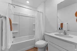Full bathroom featuring shower / bath combination with curtain, vanity, and light wood-type flooring