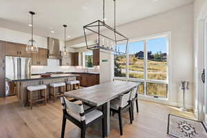 Dining space with light wood-style floors, healthy amount of natural light, a chandelier, and recessed lighting