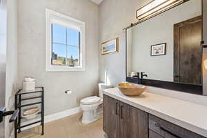 Half bathroom with vanity and light tile patterned floors