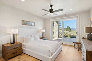 Bedroom with light wood-style flooring, ceiling fan, access to exterior, and recessed lighting