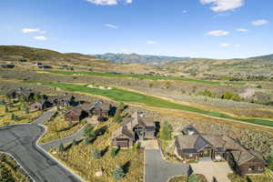 Aerial view of property's location featuring a mountain backdrop and a golf course