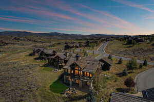 Aerial overview of property's location featuring a mountainous background and nearby suburban area