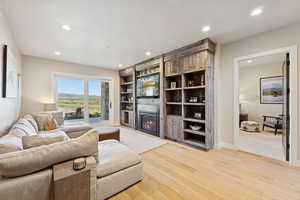 Living area featuring a fireplace, light wood-style flooring, and recessed lighting