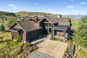View of front of home with a mountain view, a chimney, and concrete driveway