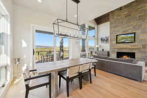 Dining area featuring light wood-style flooring, a fireplace, recessed lighting, and a chandelier