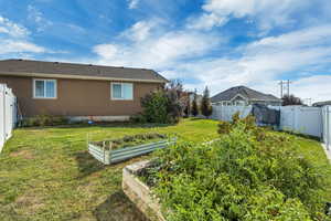 Fenced backyard featuring a vegetable garden