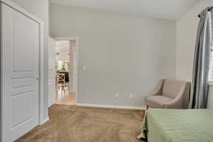 Bedroom featuring light carpet and lofted ceiling