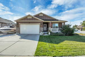 Craftsman inspired home with a porch, a front lawn, stone siding, concrete driveway, and an attached garage