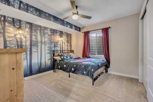 Carpeted bedroom featuring baseboards and a ceiling fan