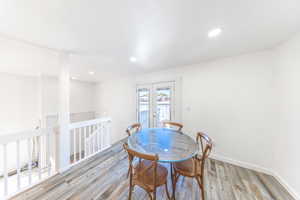 Dining space with french doors, wood finished floors, and recessed lighting