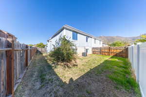 Rear view of house featuring a fenced backyard and a mountain view