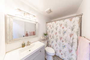 Bathroom with vanity, a shower with shower curtain, and wood finished floors