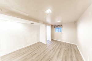Family room featuring a textured ceiling and light wood-style flooring