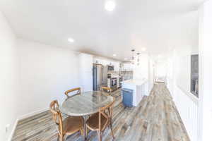 Dining room with recessed lighting and light wood-style floors. Updated kitchen with stainless steel appliances.