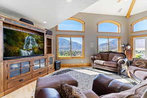 Living room with wood finished floors, a mountain view, high vaulted ceiling, a textured ceiling, and recessed lighting