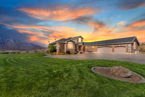 View of front of home with brick siding, a garage, a front yard, and concrete driveway