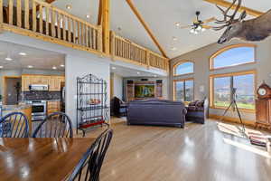 Dining area with high vaulted ceiling, ceiling fan, light wood-style flooring, and recessed lighting
