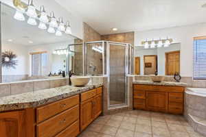Master bathroom featuring separate tub and shower with dual sinks.