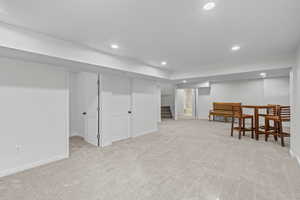 Finished below grade area with stairway, light carpet, and recessed lighting
