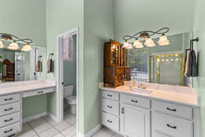 Bathroom featuring light tile patterned flooring, a stall shower, and vanity