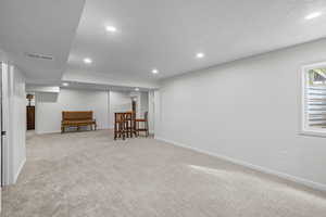 Basement with recessed lighting and light colored carpet
