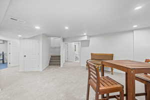 Dining room featuring light colored carpet, recessed lighting, and stairway