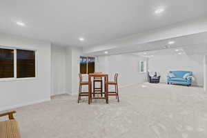 Sitting room with light colored carpet and recessed lighting