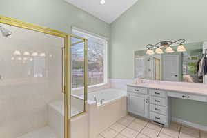 Ensuite bathroom with a shower stall, a garden tub, vanity, and light tile patterned floors