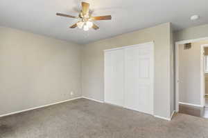 Unfurnished bedroom with carpet floors, a closet, and ceiling fan