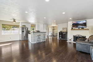 Living area featuring a fireplace, LVP Flooring, chandelier, recessed lighting, and ceiling fan