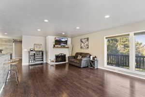 Living area with recessed lighting, LVP Flooring, and fireplace