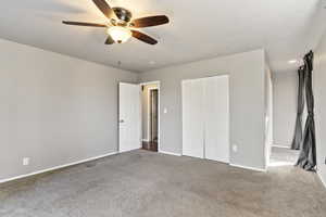 Unfurnished bedroom featuring carpet flooring, a ceiling fan, and a closet