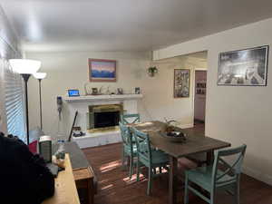 Dining space with a premium fireplace and dark wood finished floors