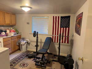 Exercise room with washer / clothes dryer and baseboards