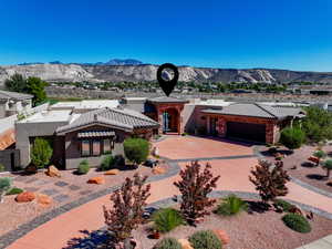 View of front facade featuring a mountain view, stucco siding, driveway, and an attached garage